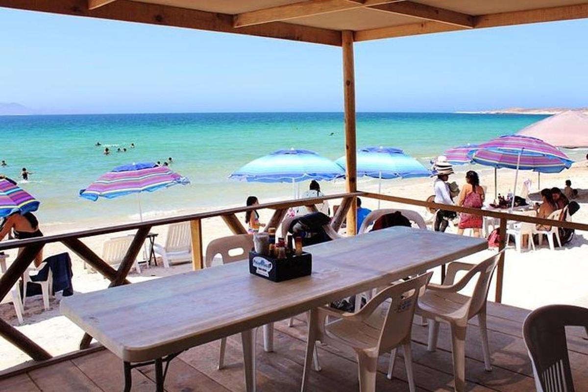 un tavolo e sedie su una spiaggia con ombrelloni