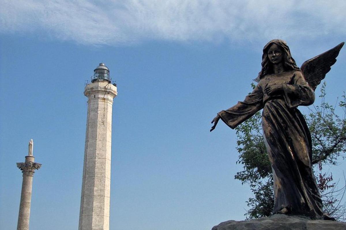 Una estatua de un ángel junto a dos torres.