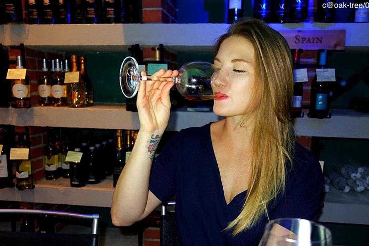 žena pije pohár vína v bare