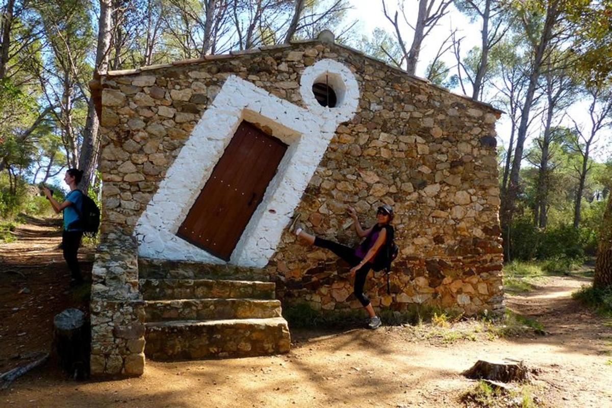 two people are standing outside of a stone building