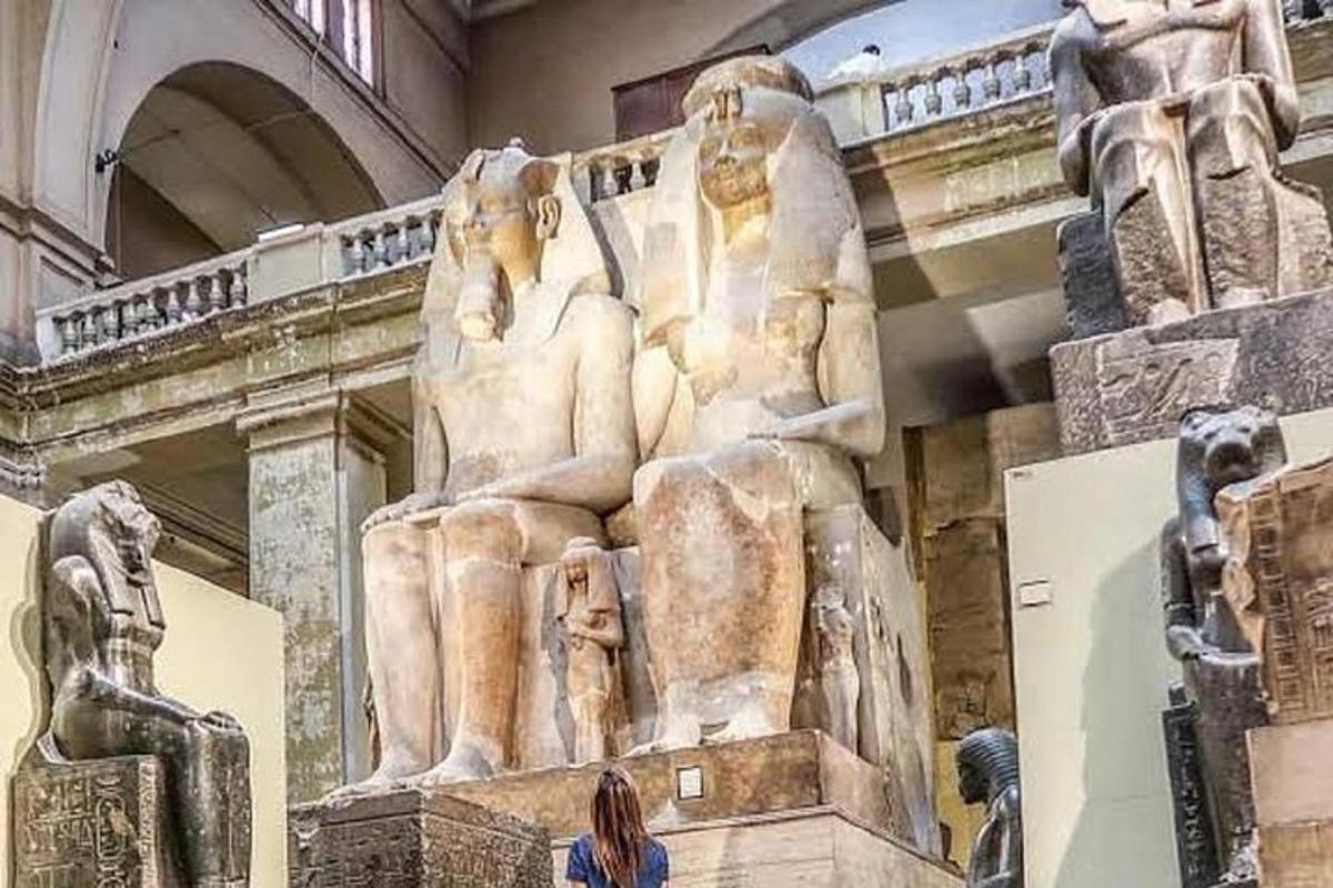 Una mujer parada frente a una estatua en un museo.
