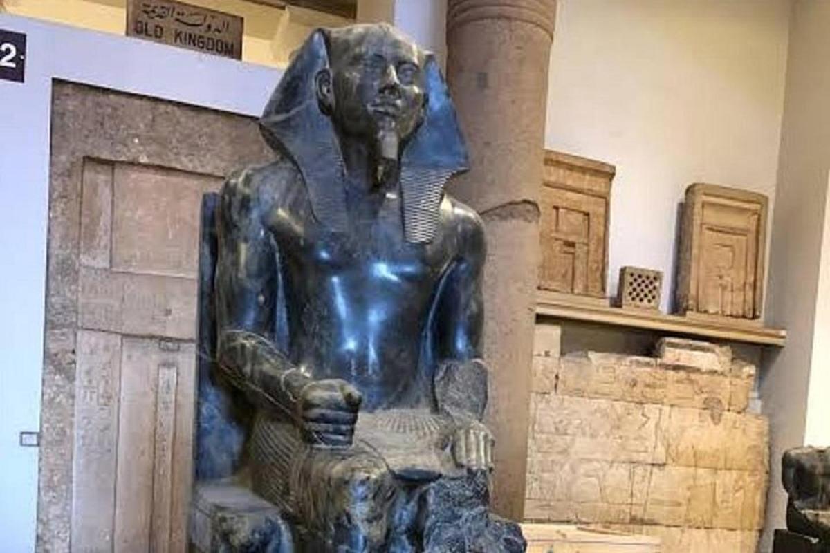una estatua de una mujer sentada frente a una chimenea
