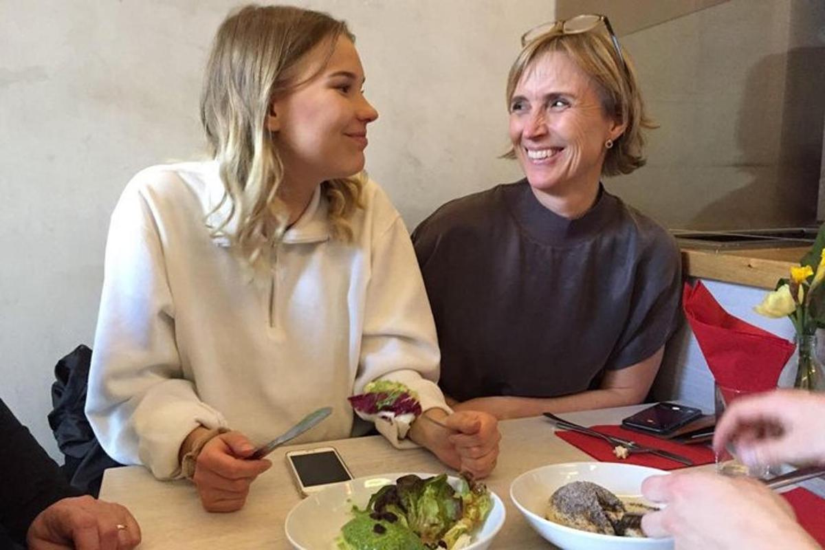 žena sedící u stolu s talířem jídla