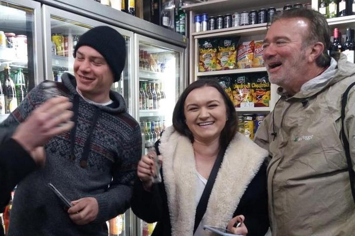 skupina tří lidí stojících v obchodě