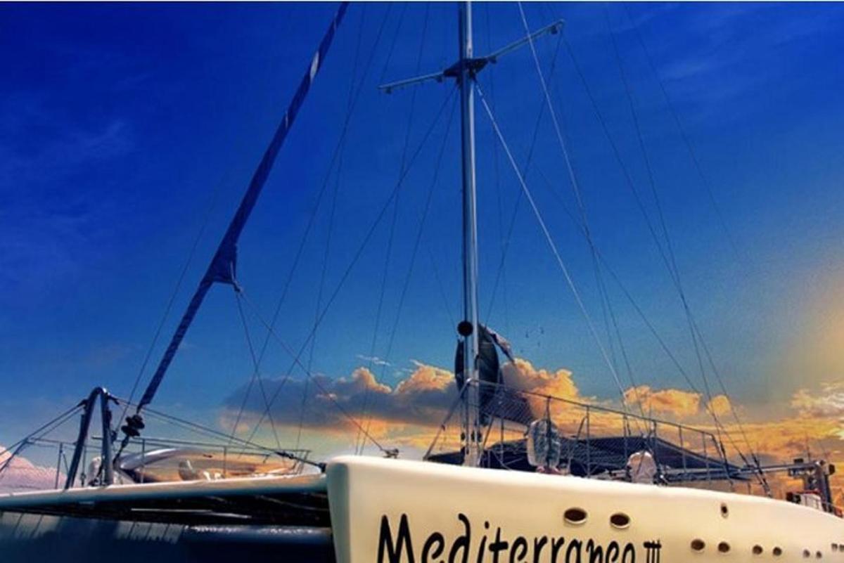 a boat sitting in the water with the sky in the background