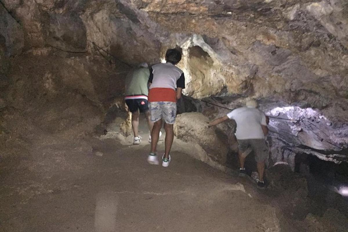 tiga orang berjalan ke dalam sebuah gua