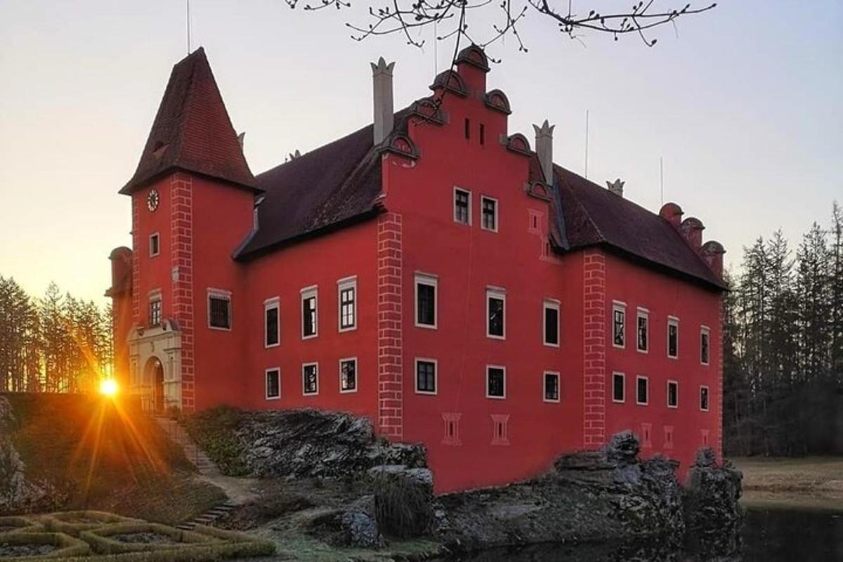 un grande edificio rosso con il sole che tramonta dietro di esso