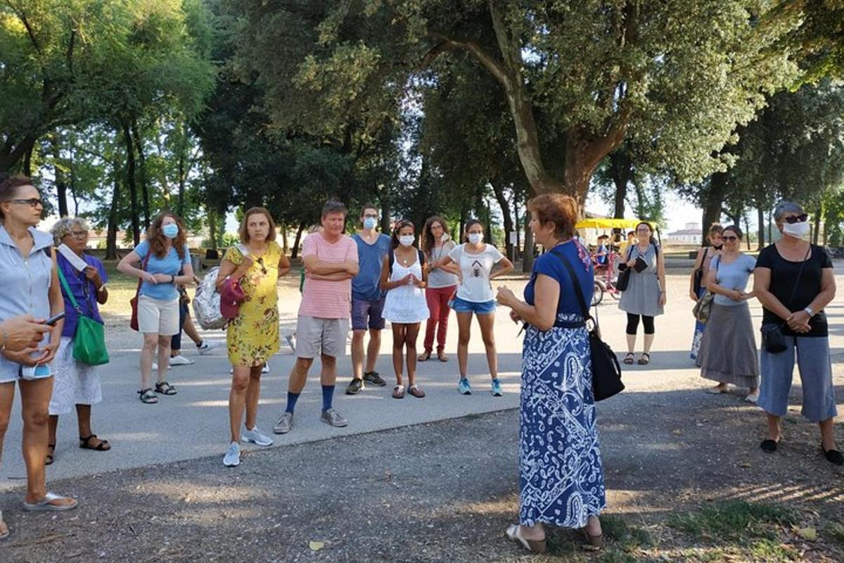 skupina lidí v rouškách stojících na chodníku