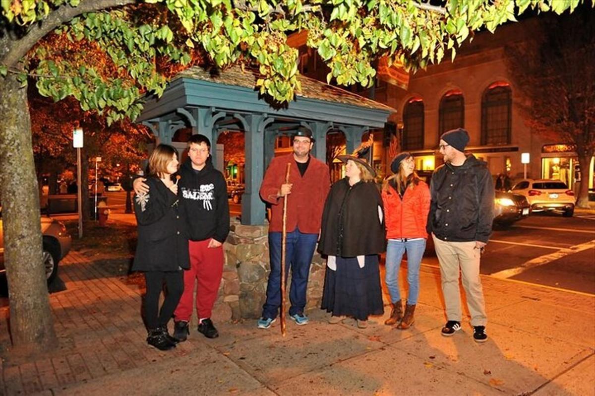 a group of people standing on a sidewalk