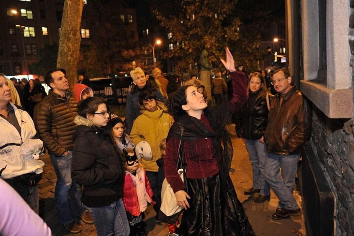 a crowd of people standing on a street at night