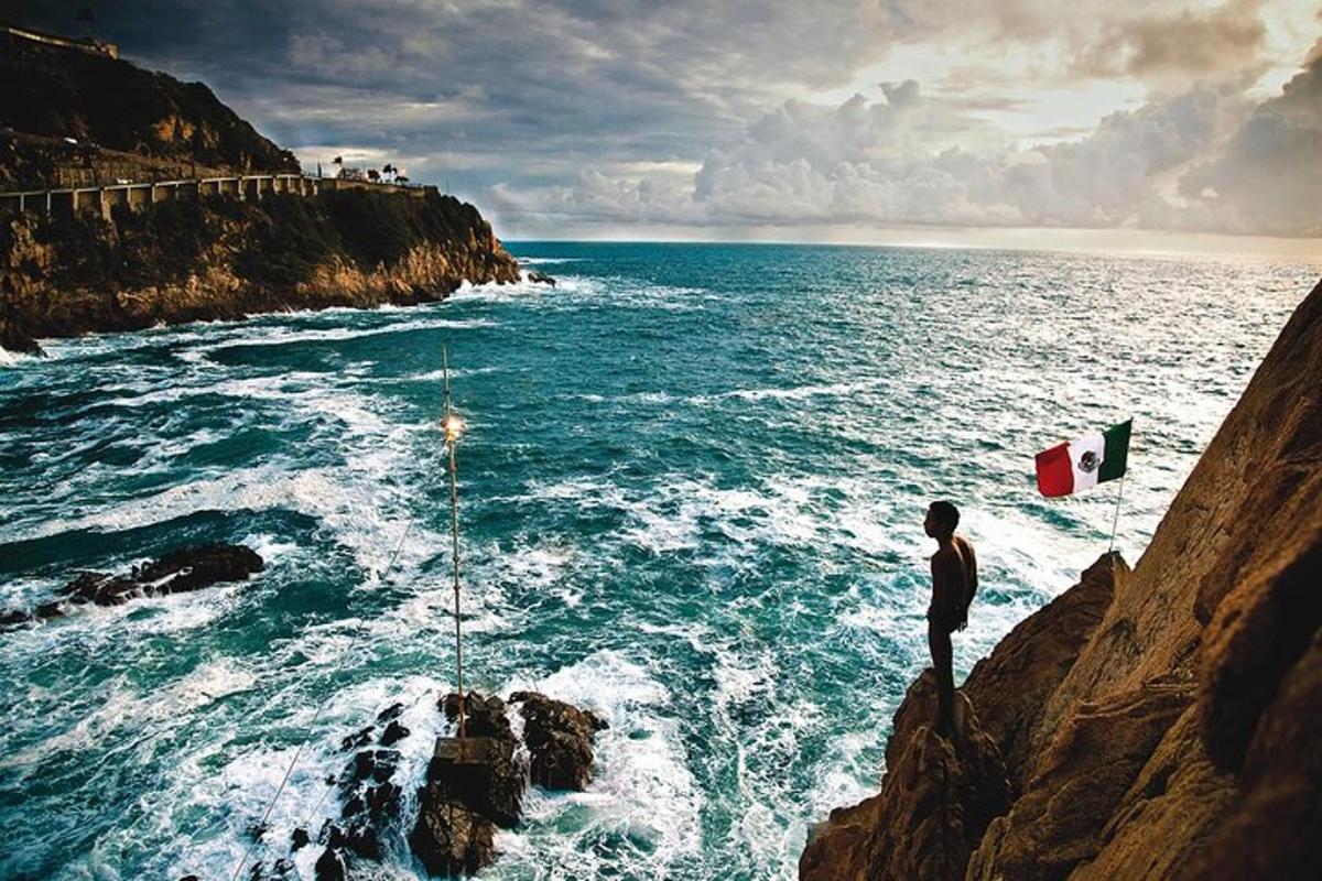 a man standing on a cliff looking at the ocean