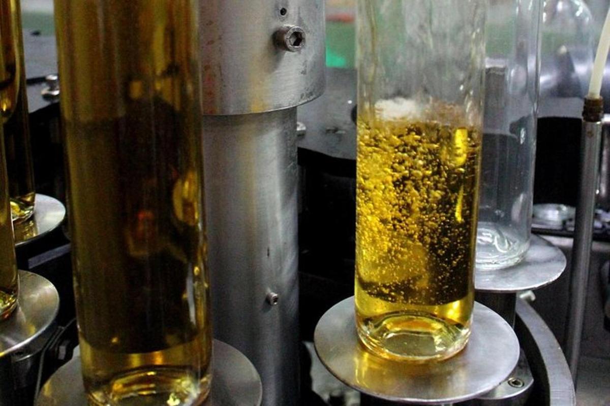 two glass vases filled with yellow liquid on a machine