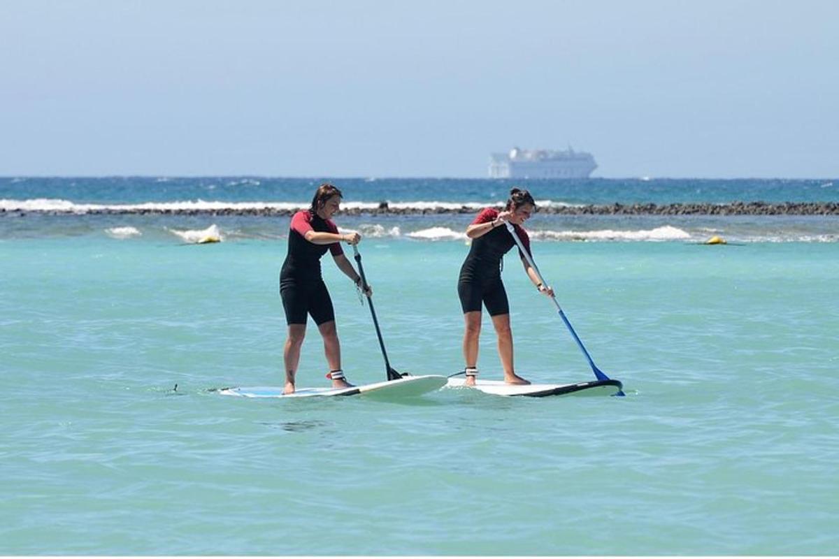 two women are paddle boarding in the ocean