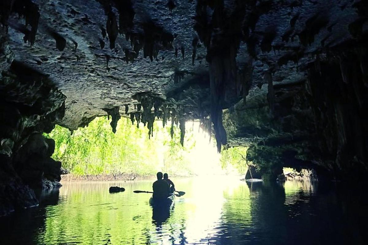 una persona seduta su un kayak in una grotta