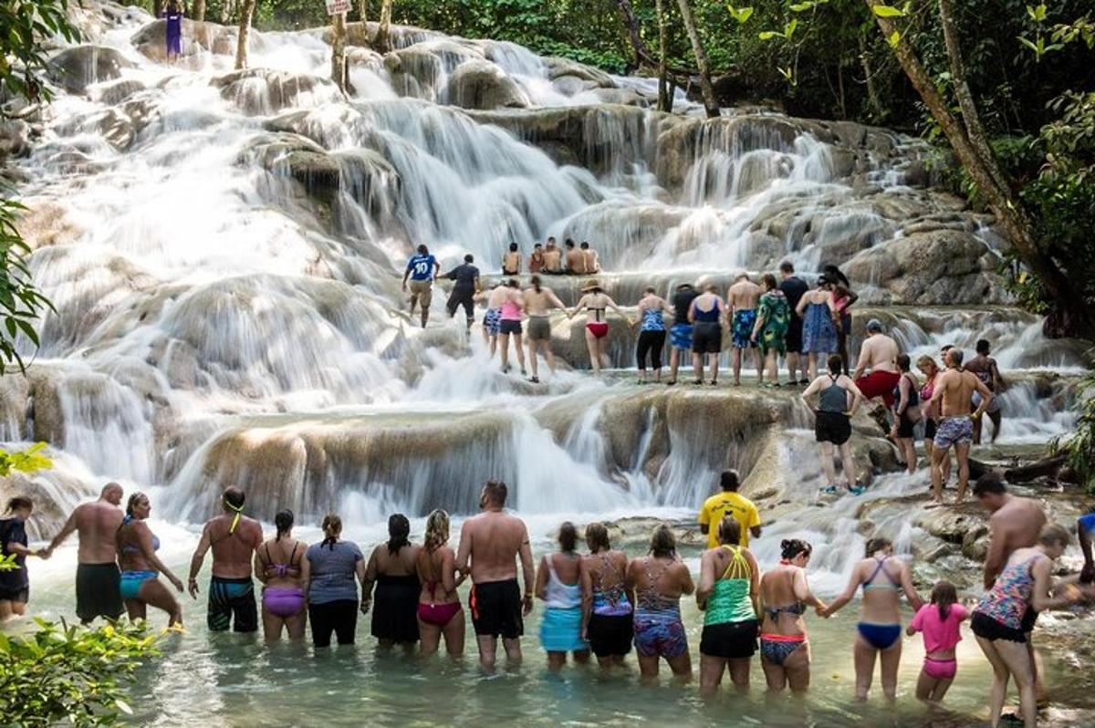 sekumpulan orang berdiri di dalam air di air terjun