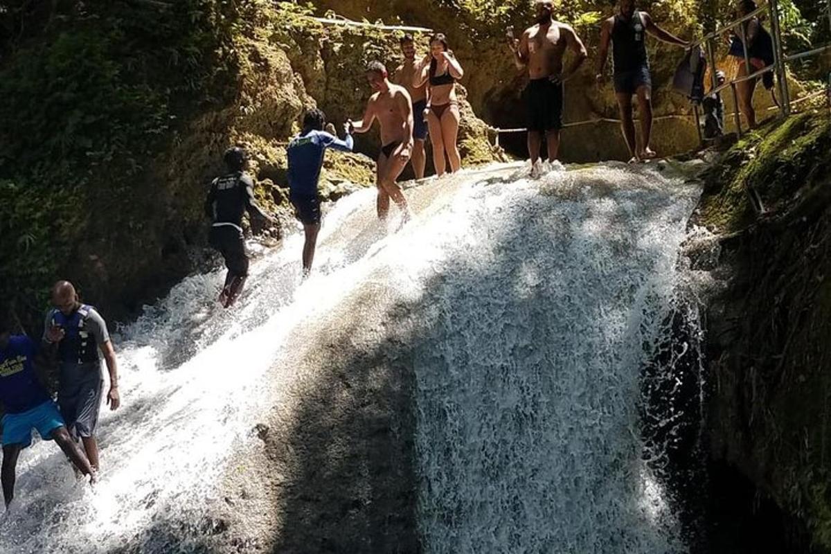 sekumpulan orang berjalan di sepanjang air terjun