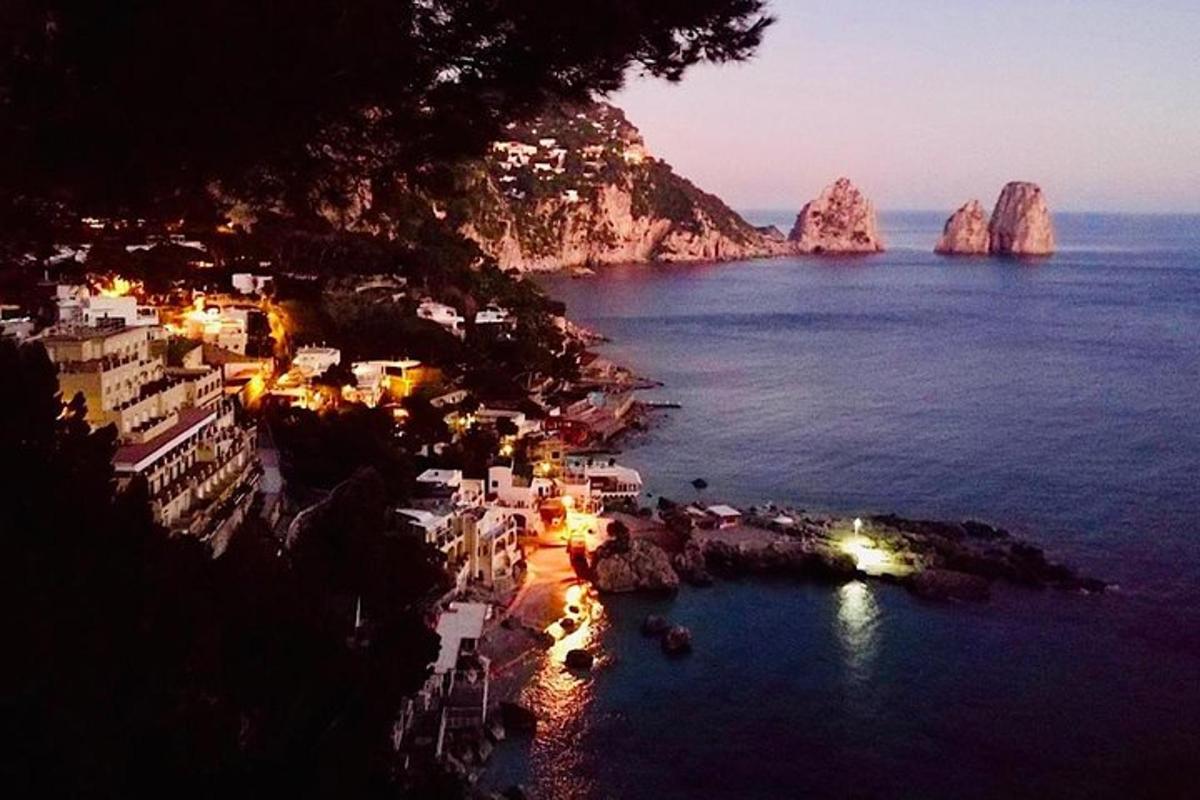 a view of a town with the ocean at night