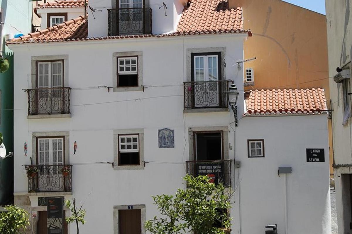 Ένα λευκό κτίριο με παράθυρα και μπαλκόνια σε έναν δρόμο