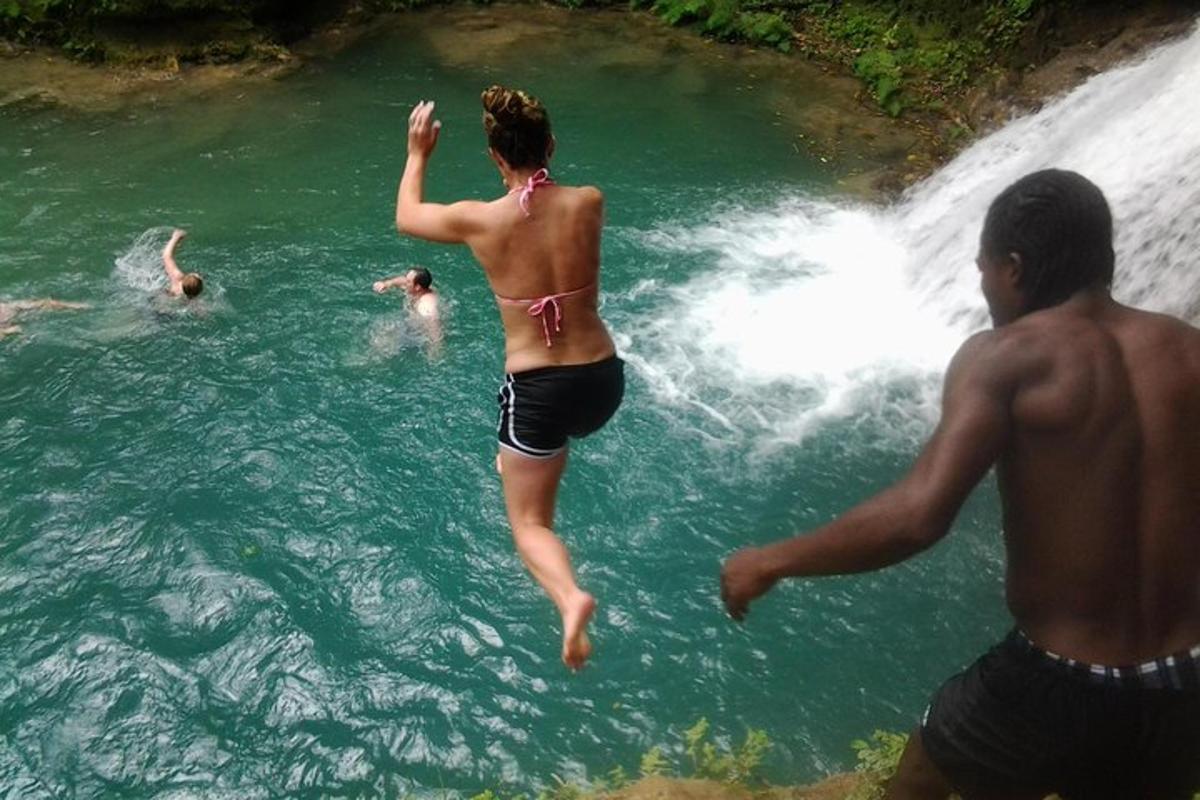 una mujer saltando a una cascada en un río