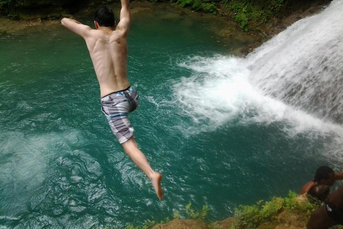 Un hombre está saltando a una cascada en el agua.