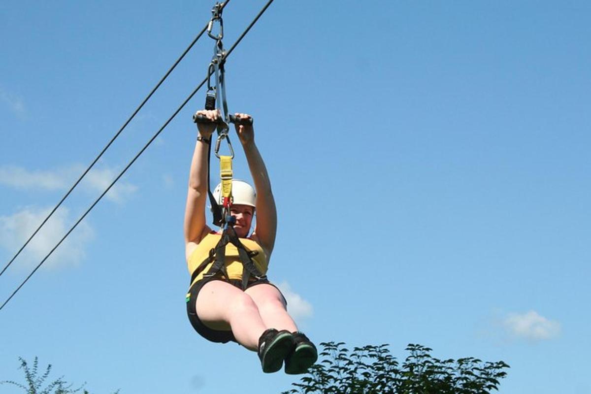 a person hanging from a zip line