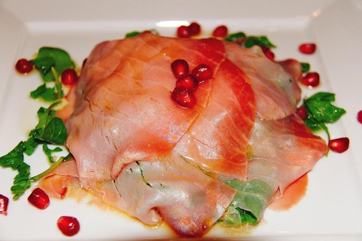 a piece of ham on a white plate with cranberries