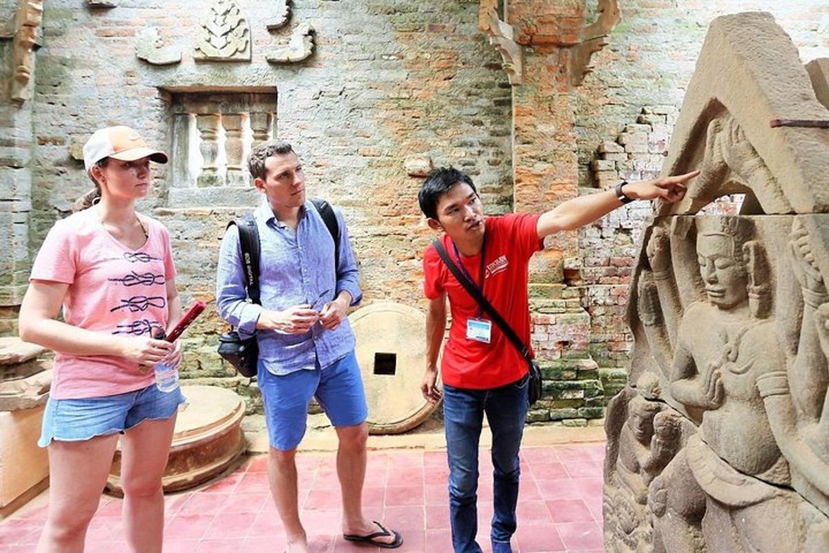a group of three people standing next to a statue