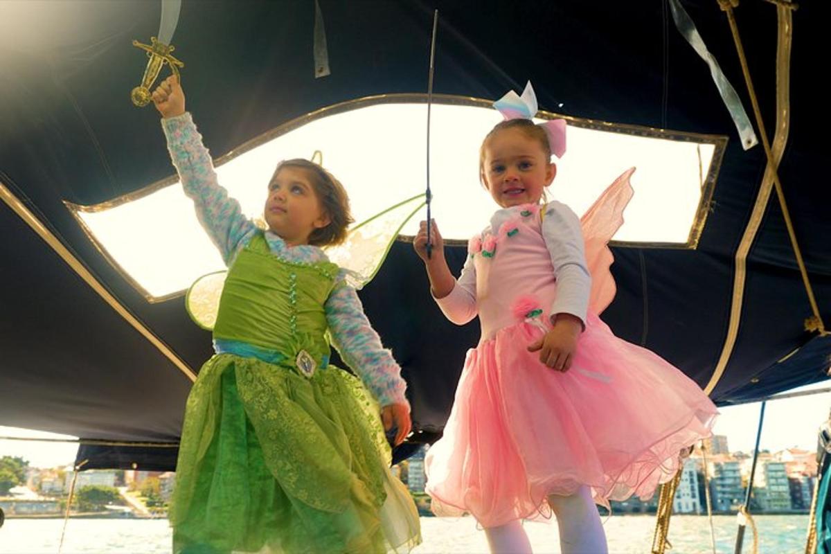 Dos niñas vestidas con disfraces de hadas de pie bajo un paraguas
