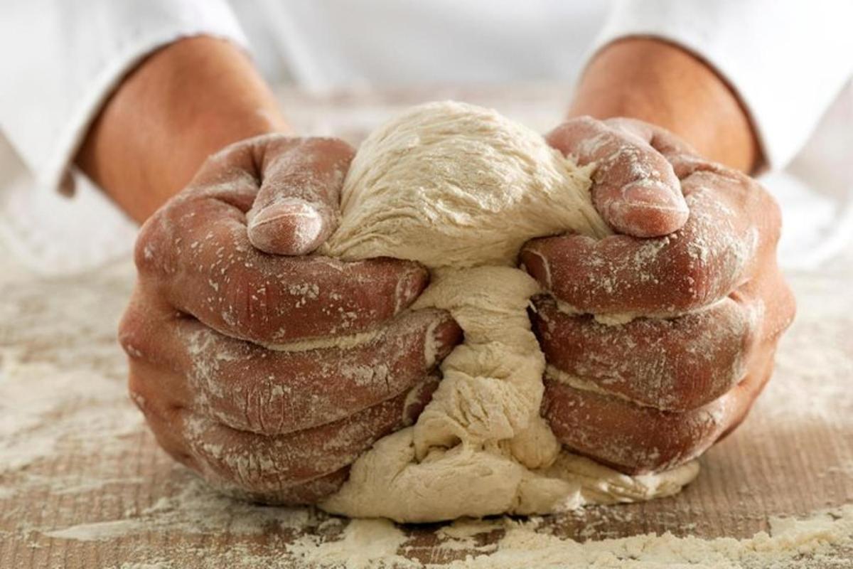 un paio di mani che tengono un mucchio di pasta