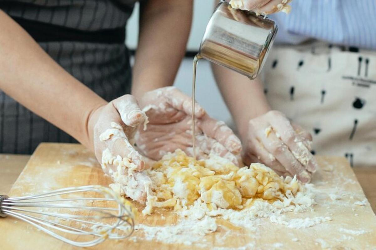 seseorang sedang menuangkan makanan ke talenan
