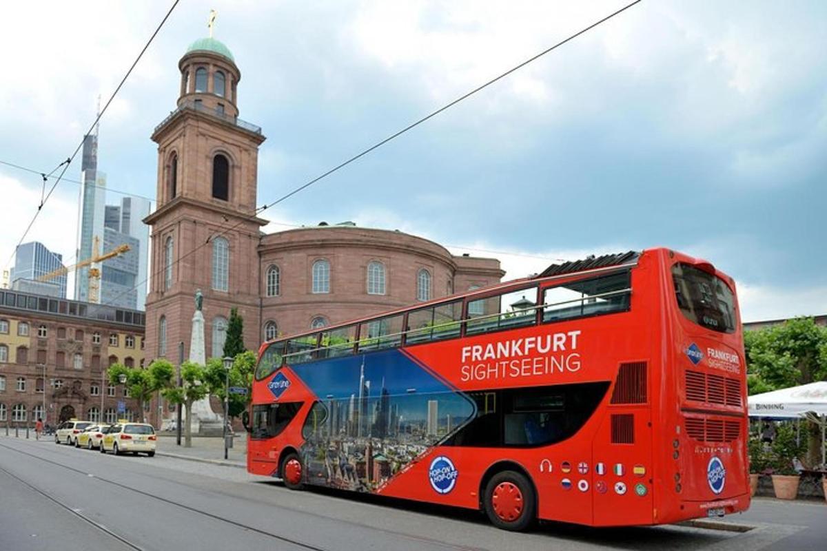 a red double decker bus driving down a city street