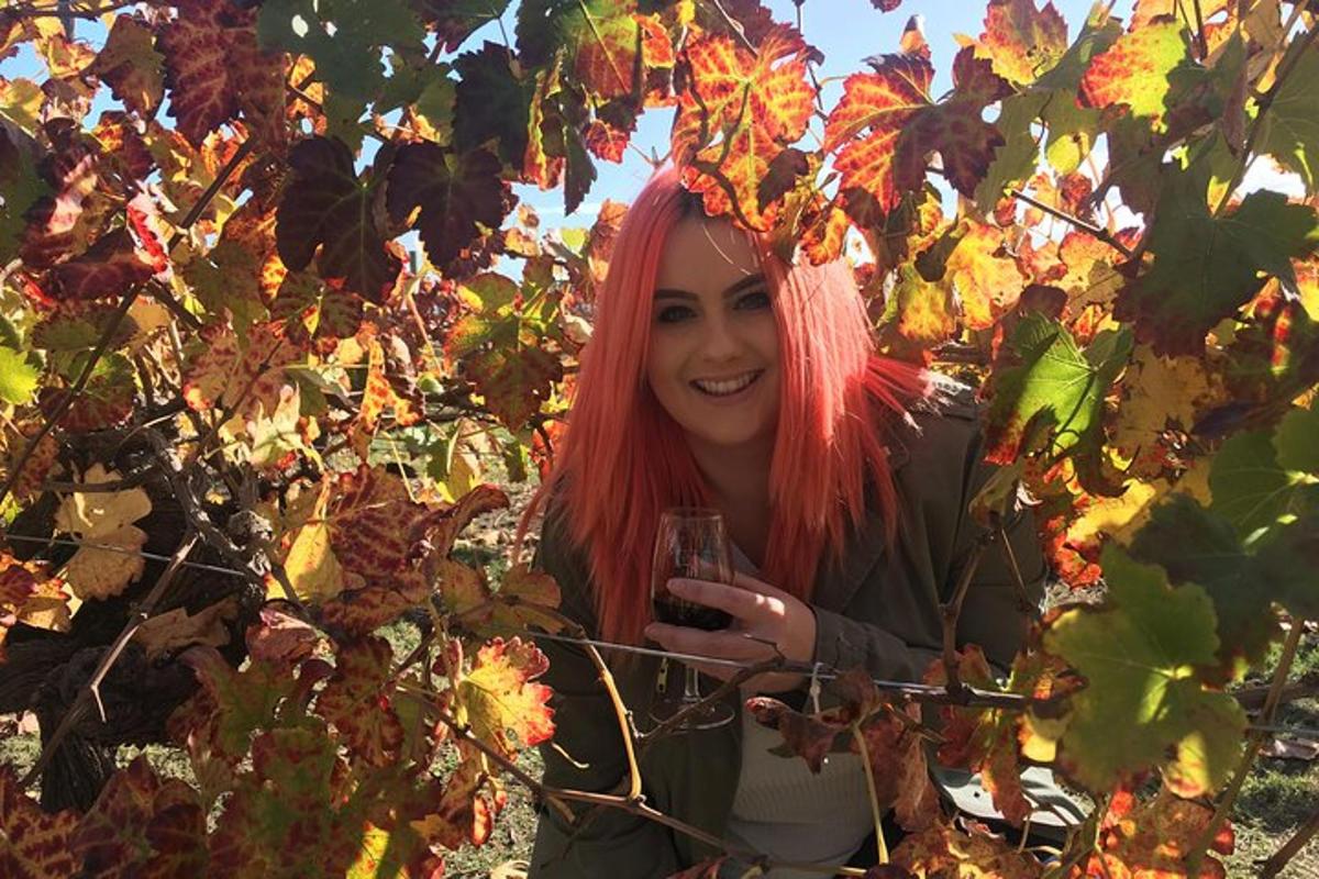 una donna con i capelli rossi che tiene in mano un bicchiere di vino