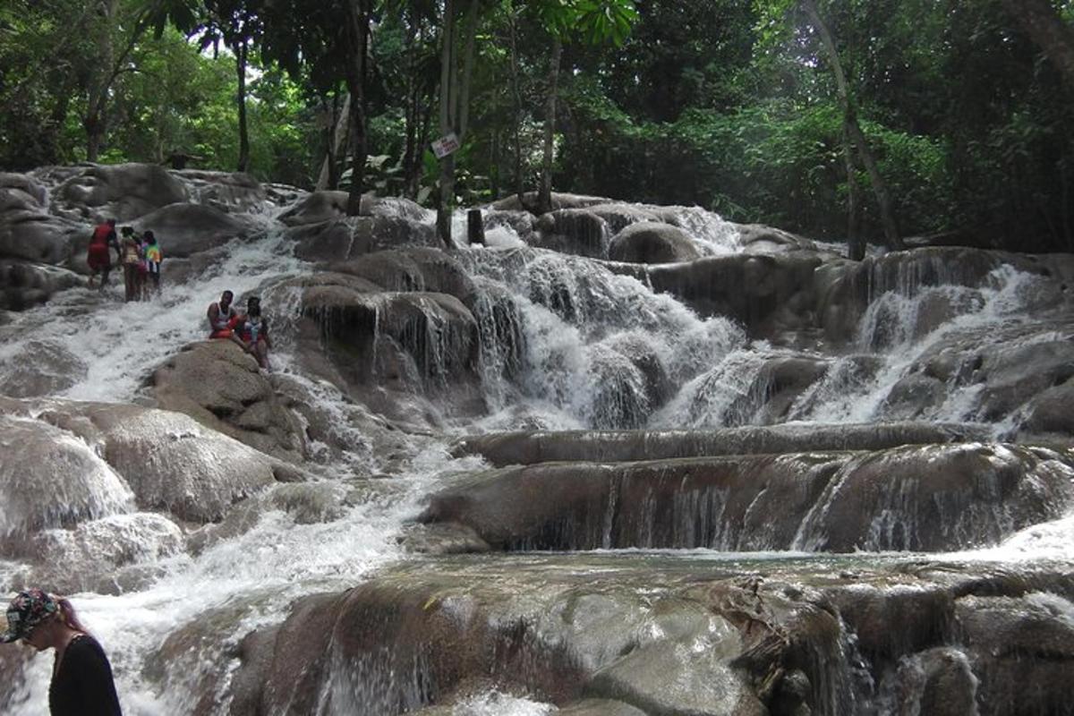 Un grupo de personas de pie sobre las rocas en una cascada.
