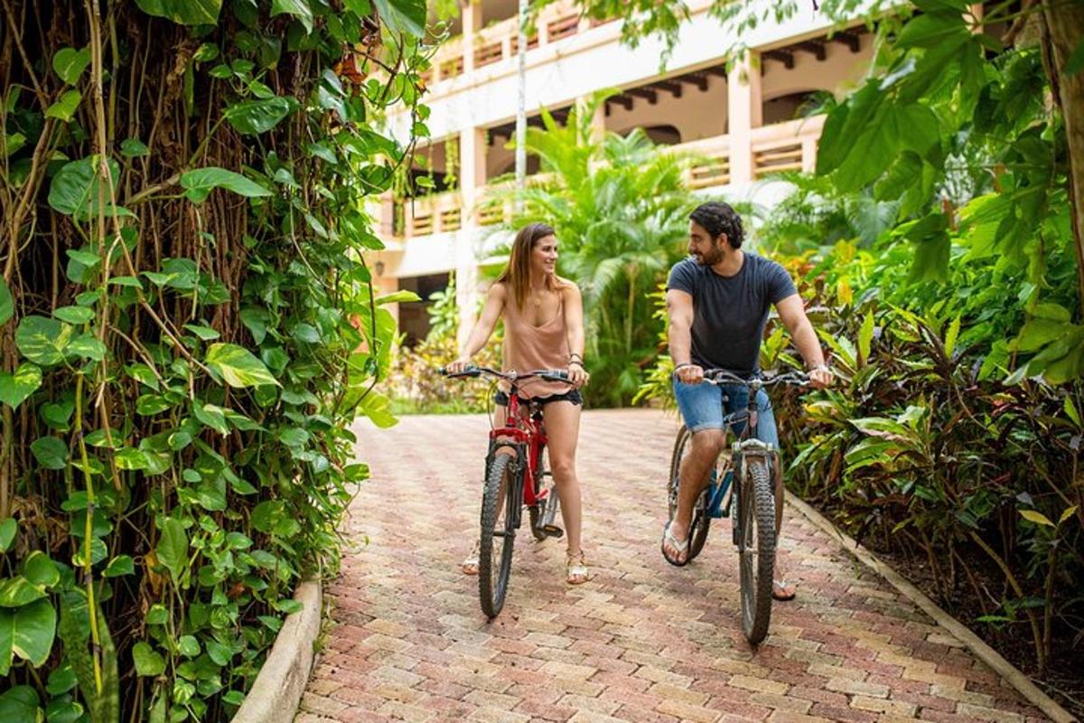 a man and woman riding bikes down a brick path