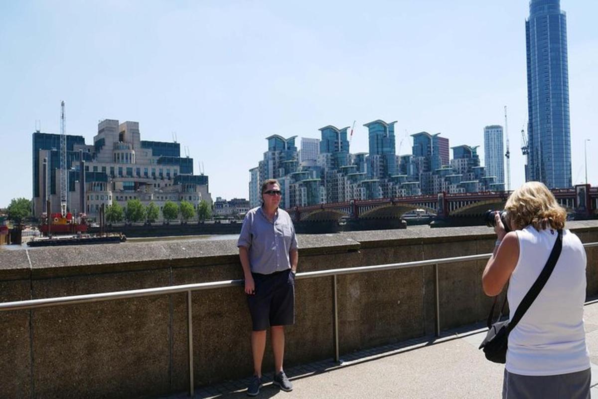 um homem em pé em uma ponte com uma mulher tirando uma foto