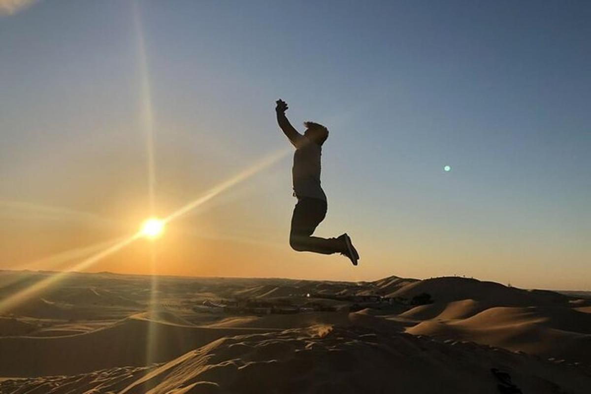 un uomo che salta in aria sopra un deserto