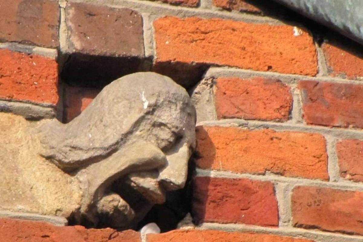 una estatua de una cara en una pared de ladrillos