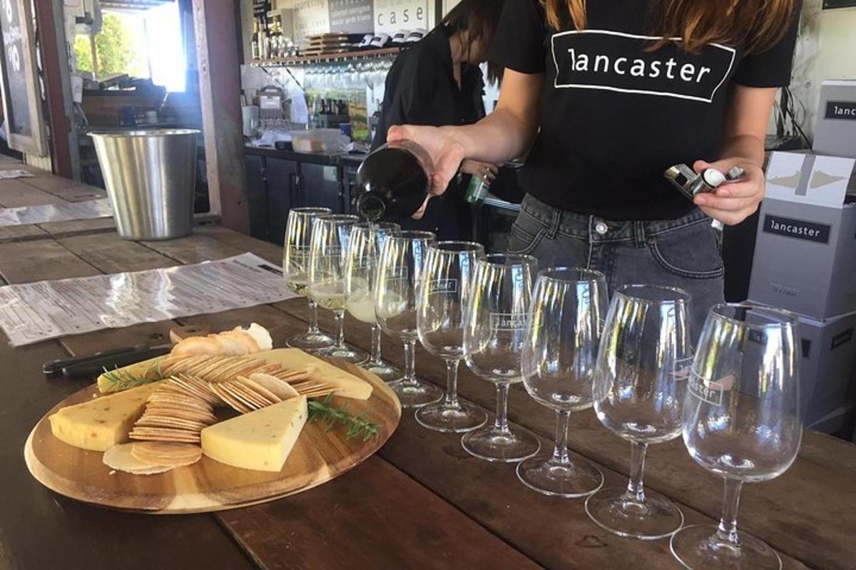 a woman pouring wine into wine glasses on a table