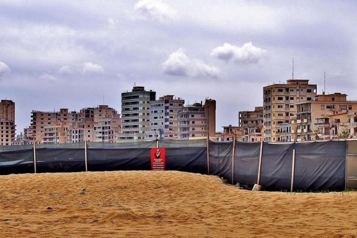 a fence in front of a city with tall buildings