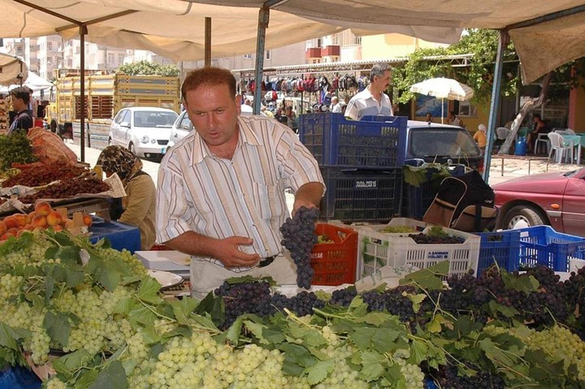 muž připravující hrozny na venkovním farmářském trhu