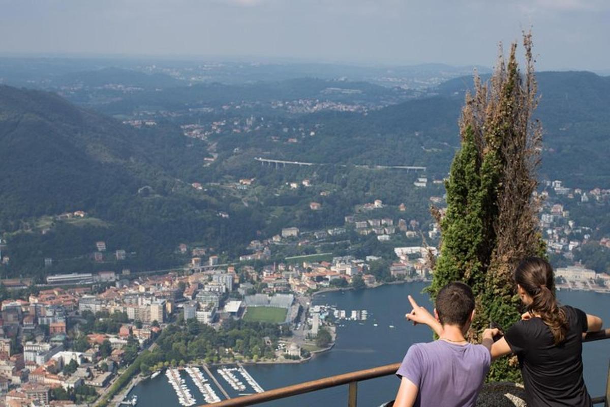 due persone in piedi su una sporgenza che guardano una città
