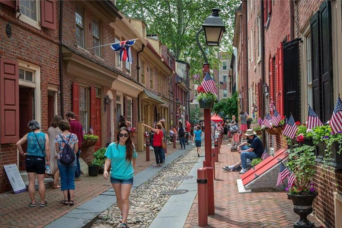 a group of people walking down a street with american flags