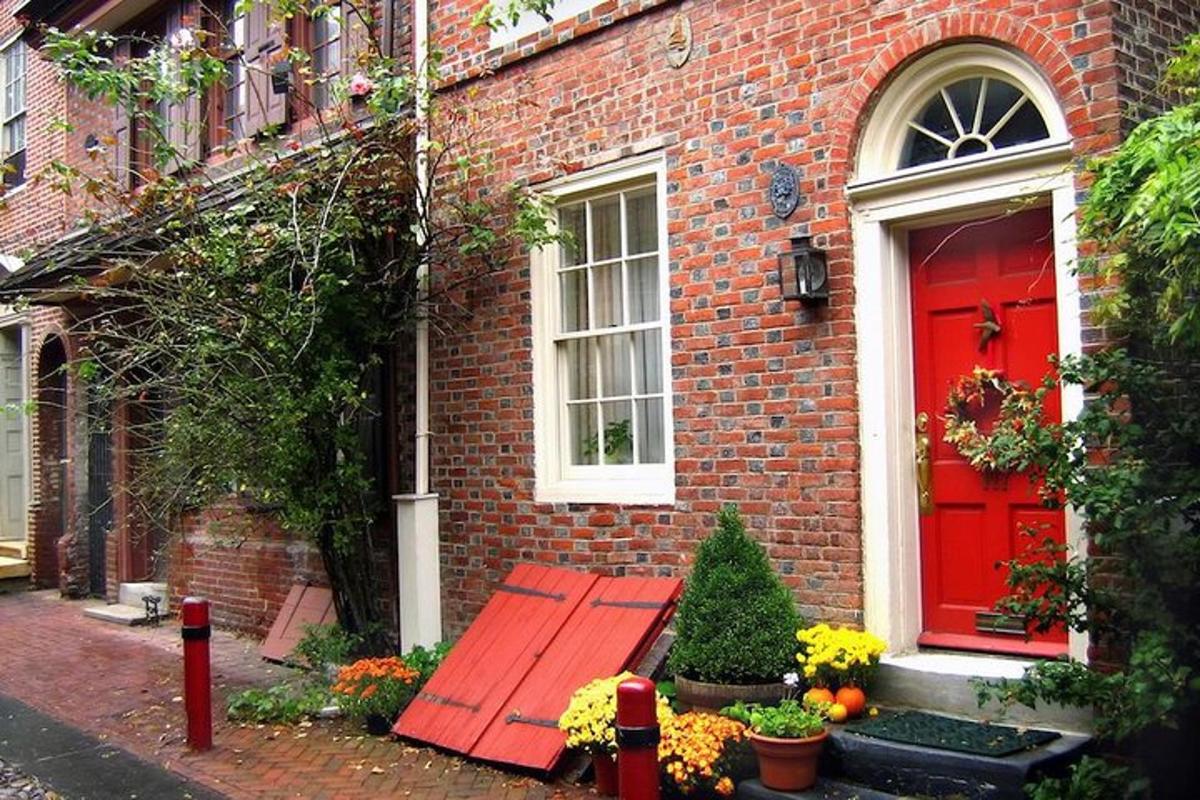 a red door on a brick house with a red bench