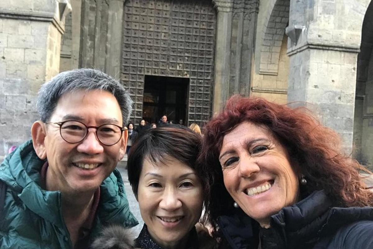 tres persones posant per a una foto davant d'un edifici