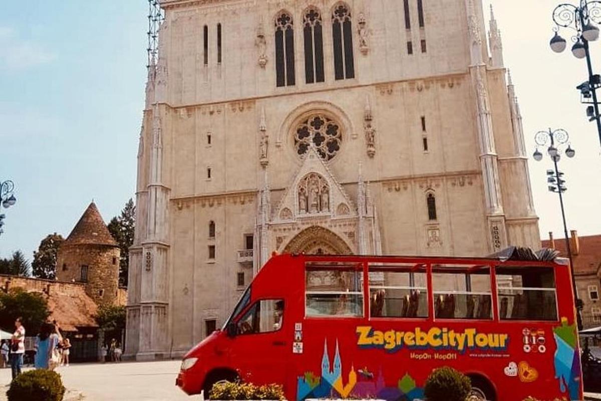 um ônibus vermelho estacionado em frente a uma igreja