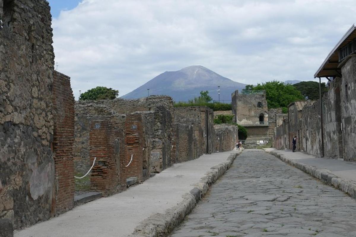 un vicolo di pietra con una montagna sullo sfondo
