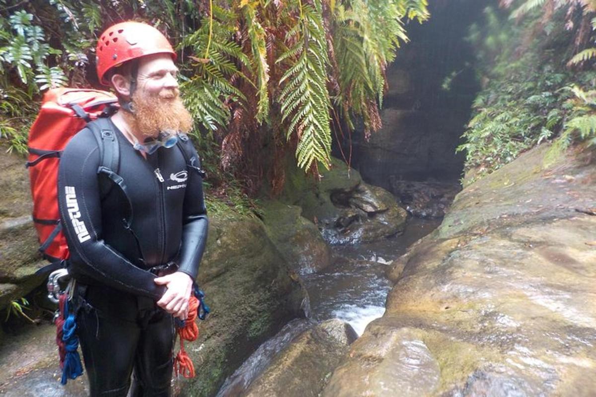 a man wearing a helmet standing next to a stream