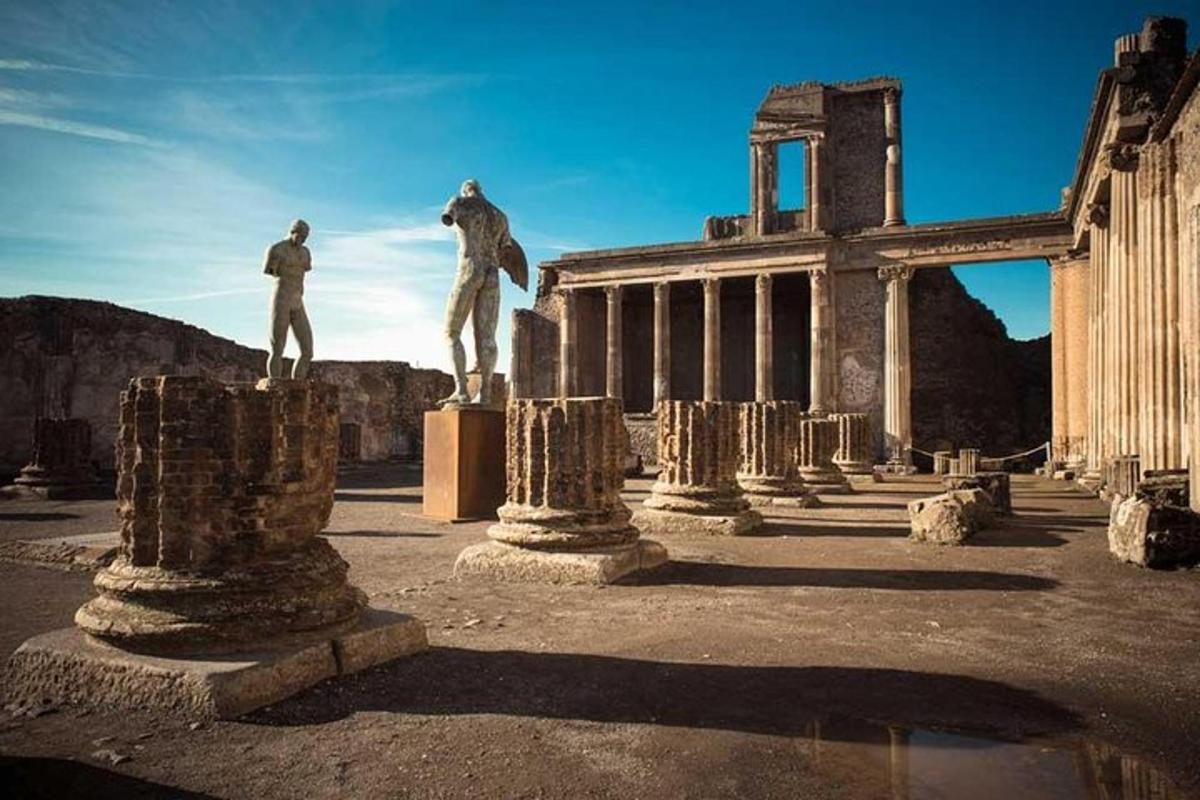ένα άγαλμα δύο ανθρώπων σε πυλώνες μπροστά από ένα κτίριο