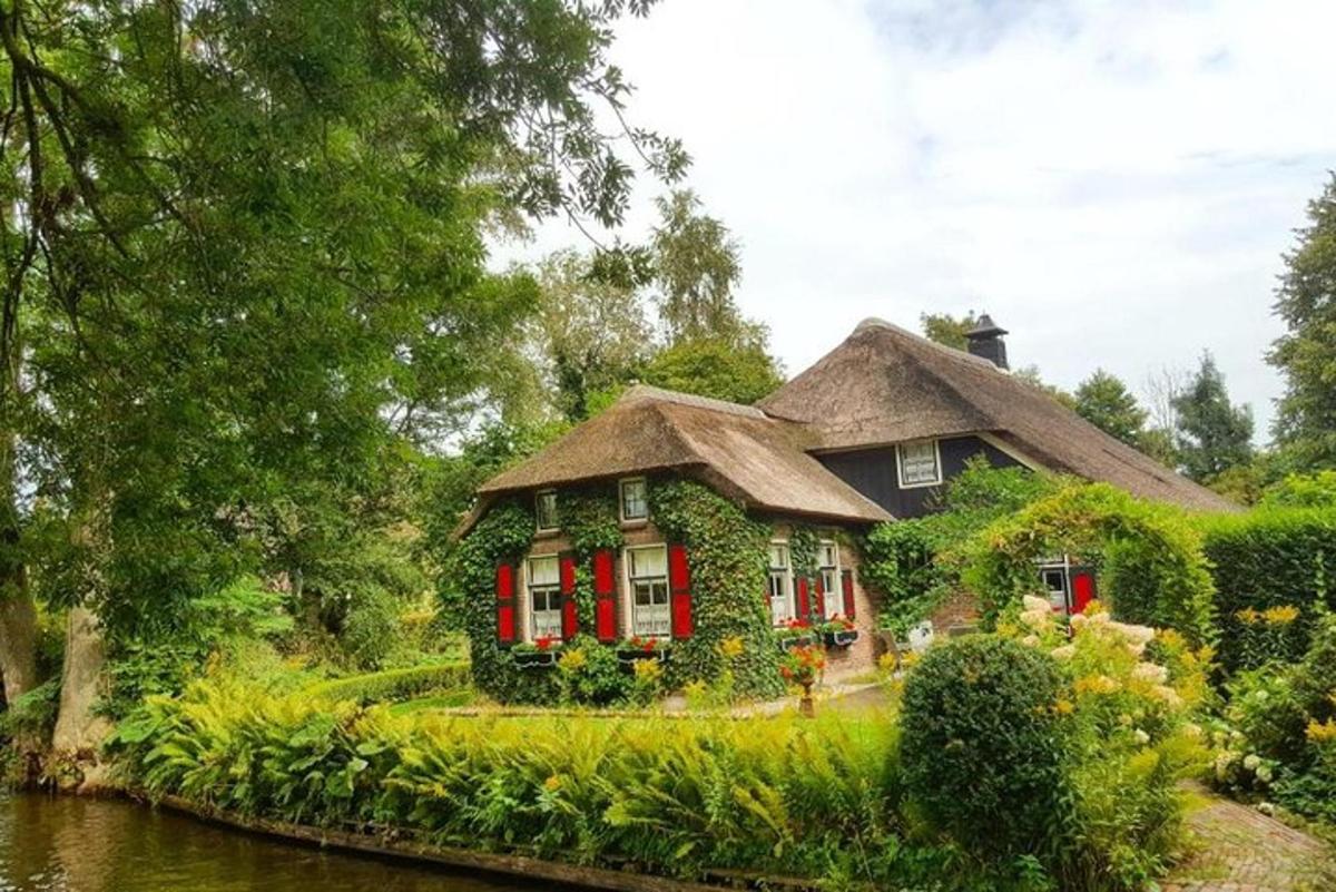 una casa con le persiane rosse su un fiume