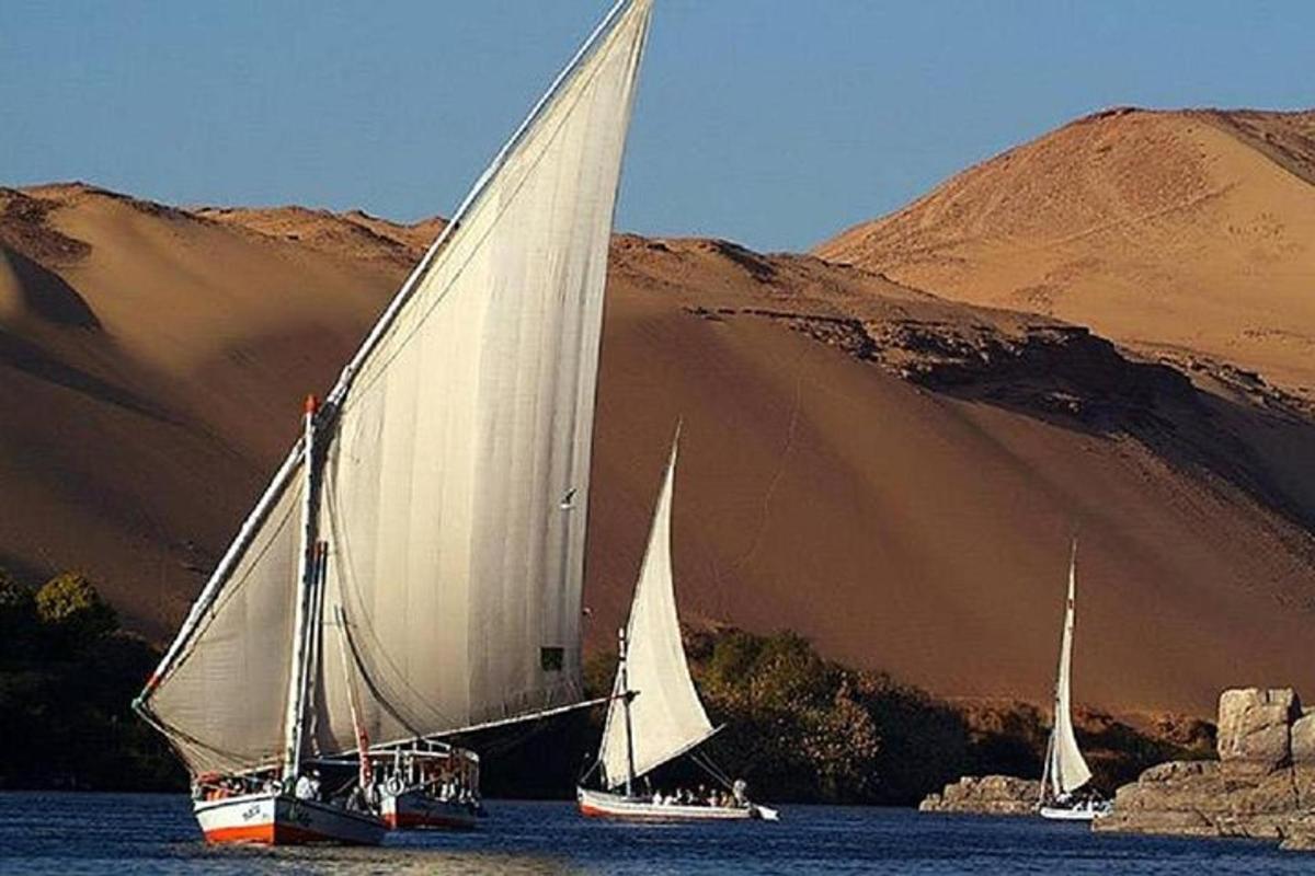 dois veleiros na água com uma montanha ao fundo